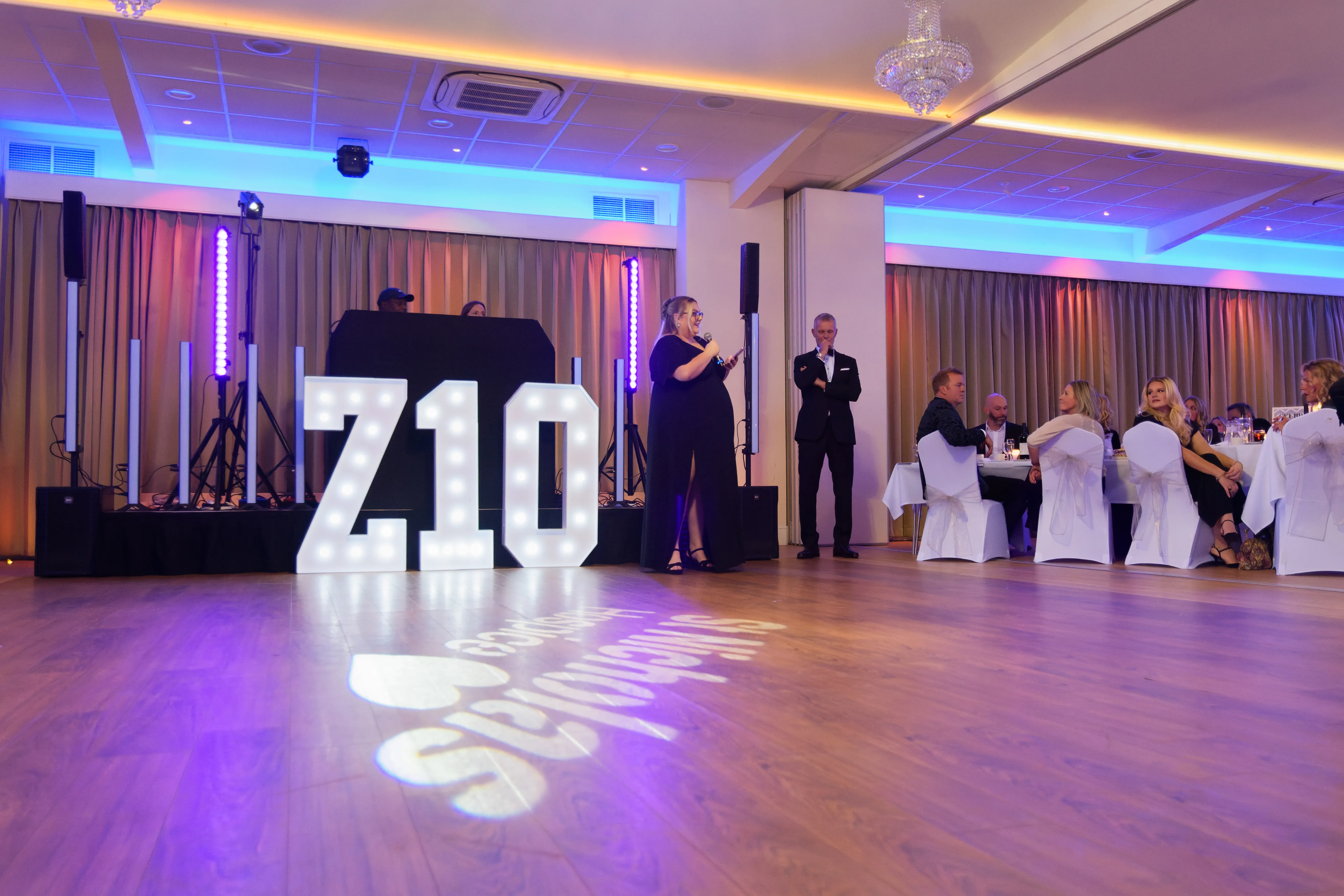 Light-up Z10 letters on the dancefloor of a ballroom lit in blue and pink.