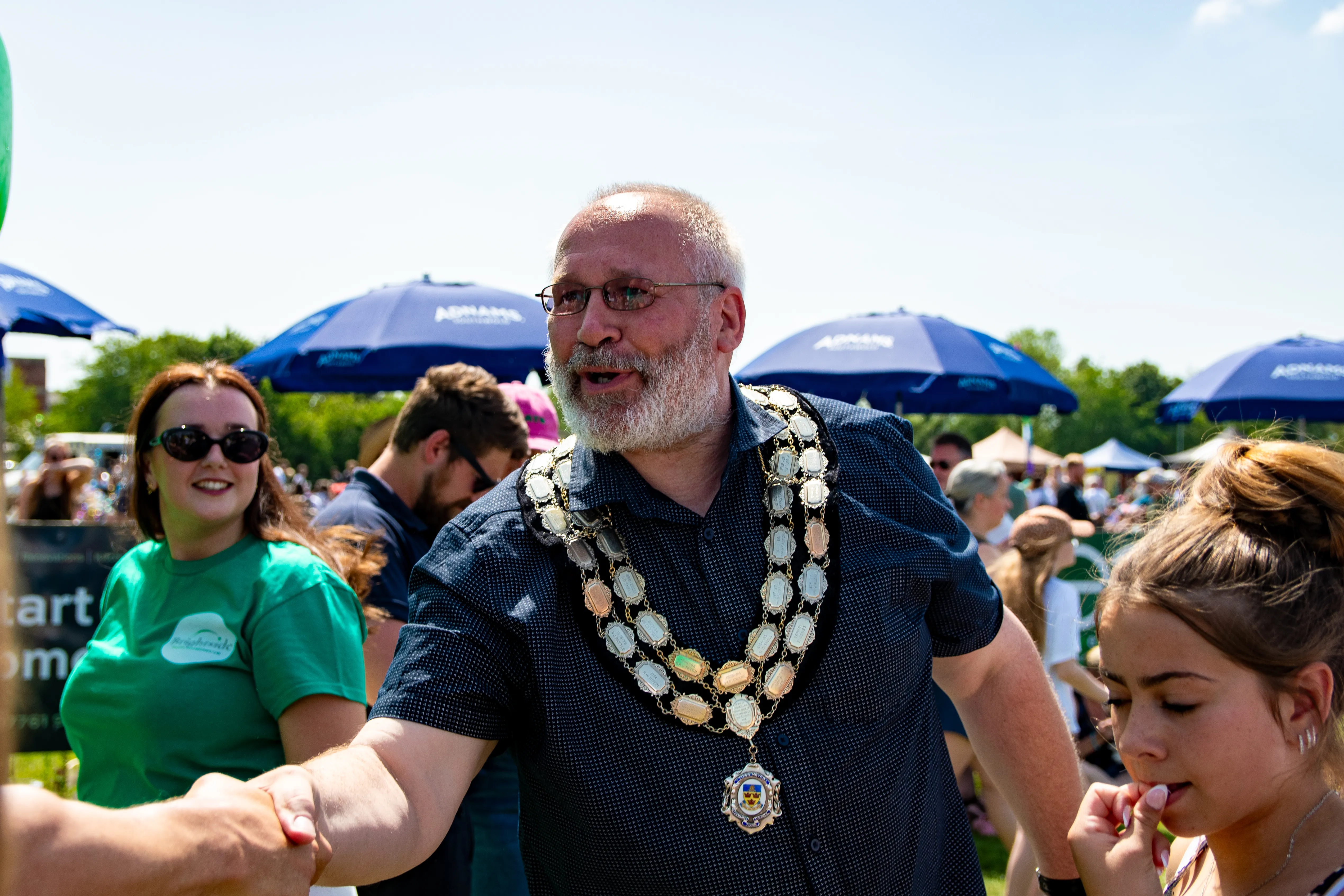 The mayor in his ceremonial chain laughing with festivalgoers.