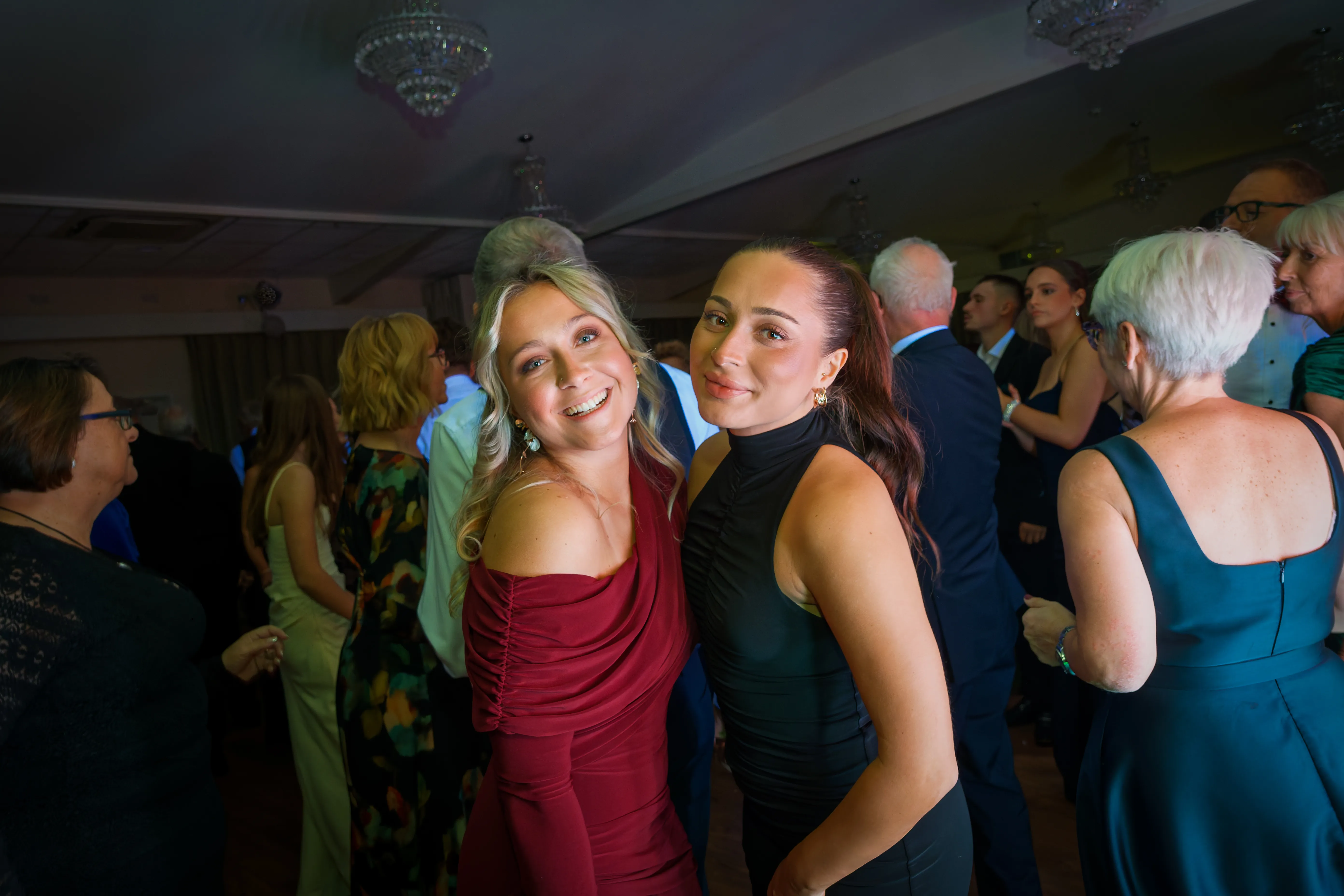 Two guests smiling over their shoulders on the dancefloor.