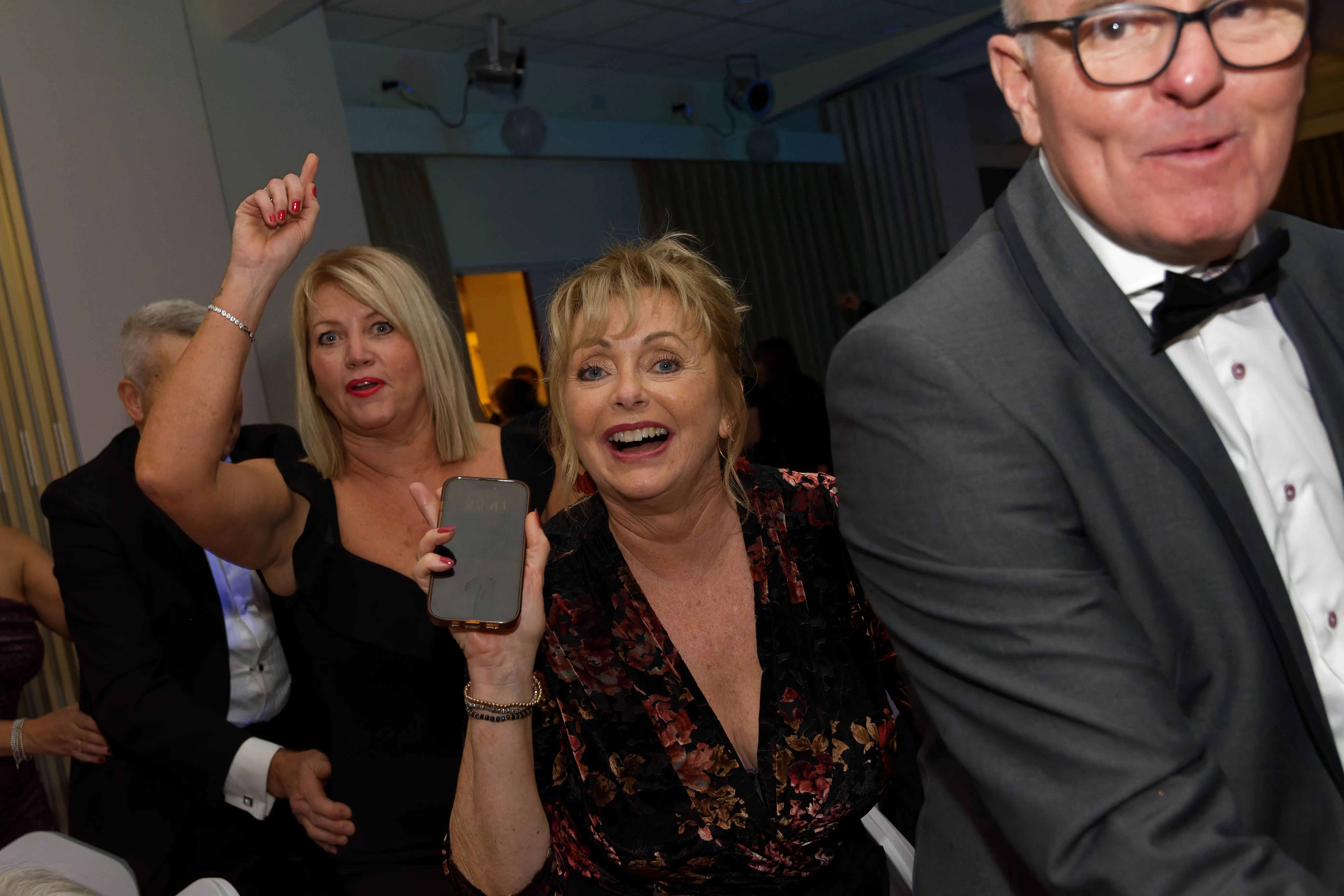 Guests dancing together, one raising an arm mid-song.
