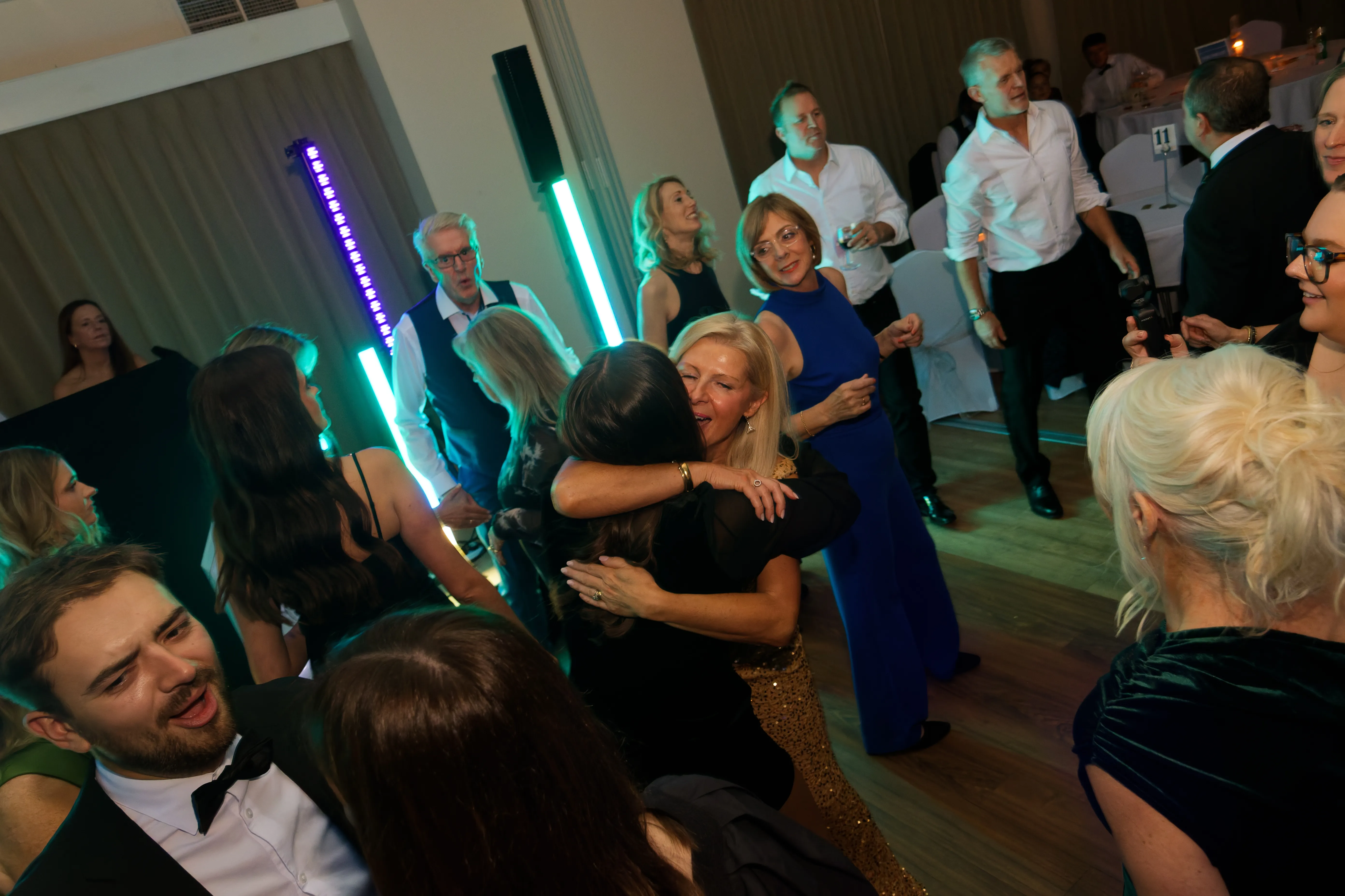 Two guests embracing amid glowing light sticks on the dancefloor.