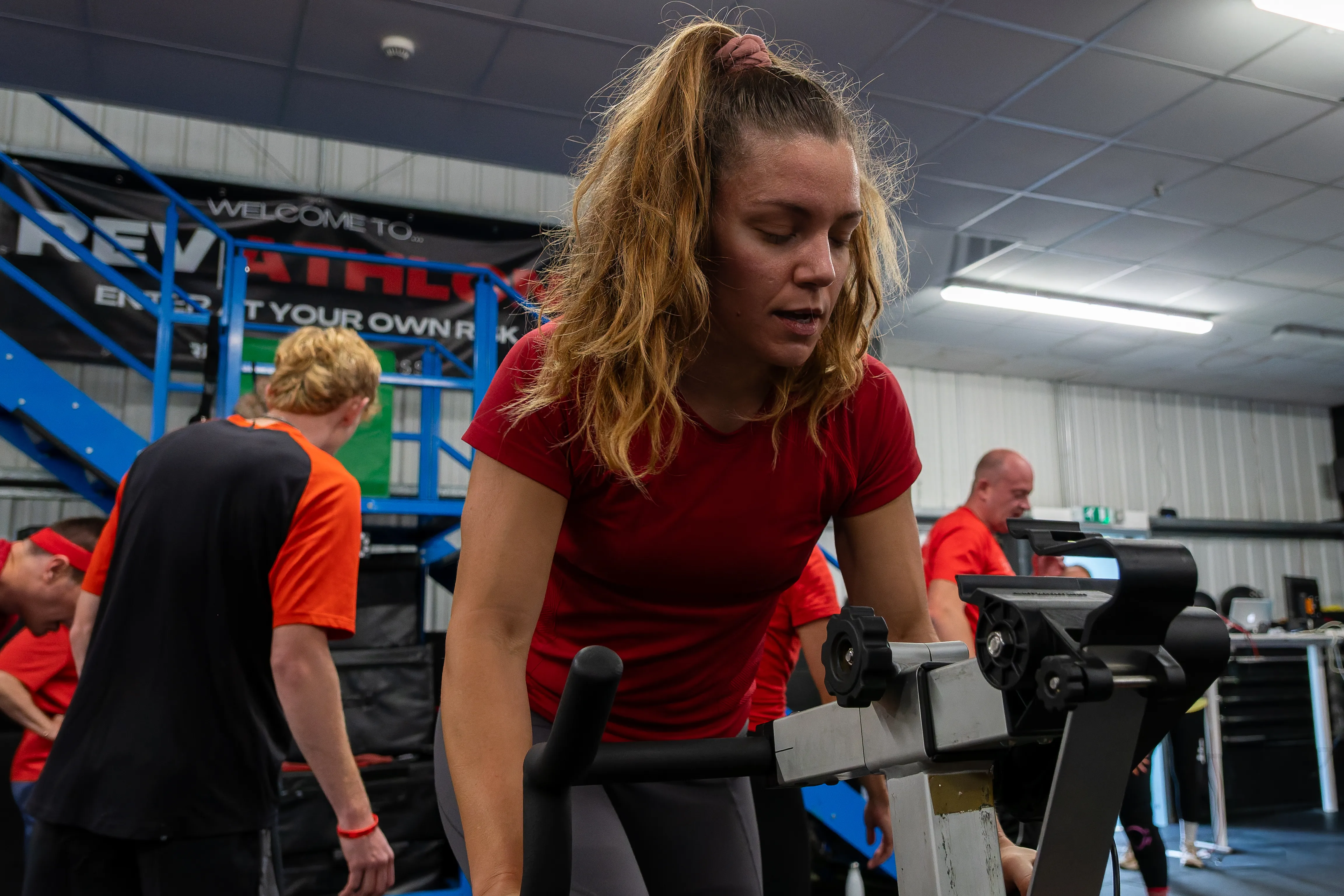 A competitor in red deep into a machine effort, face set.