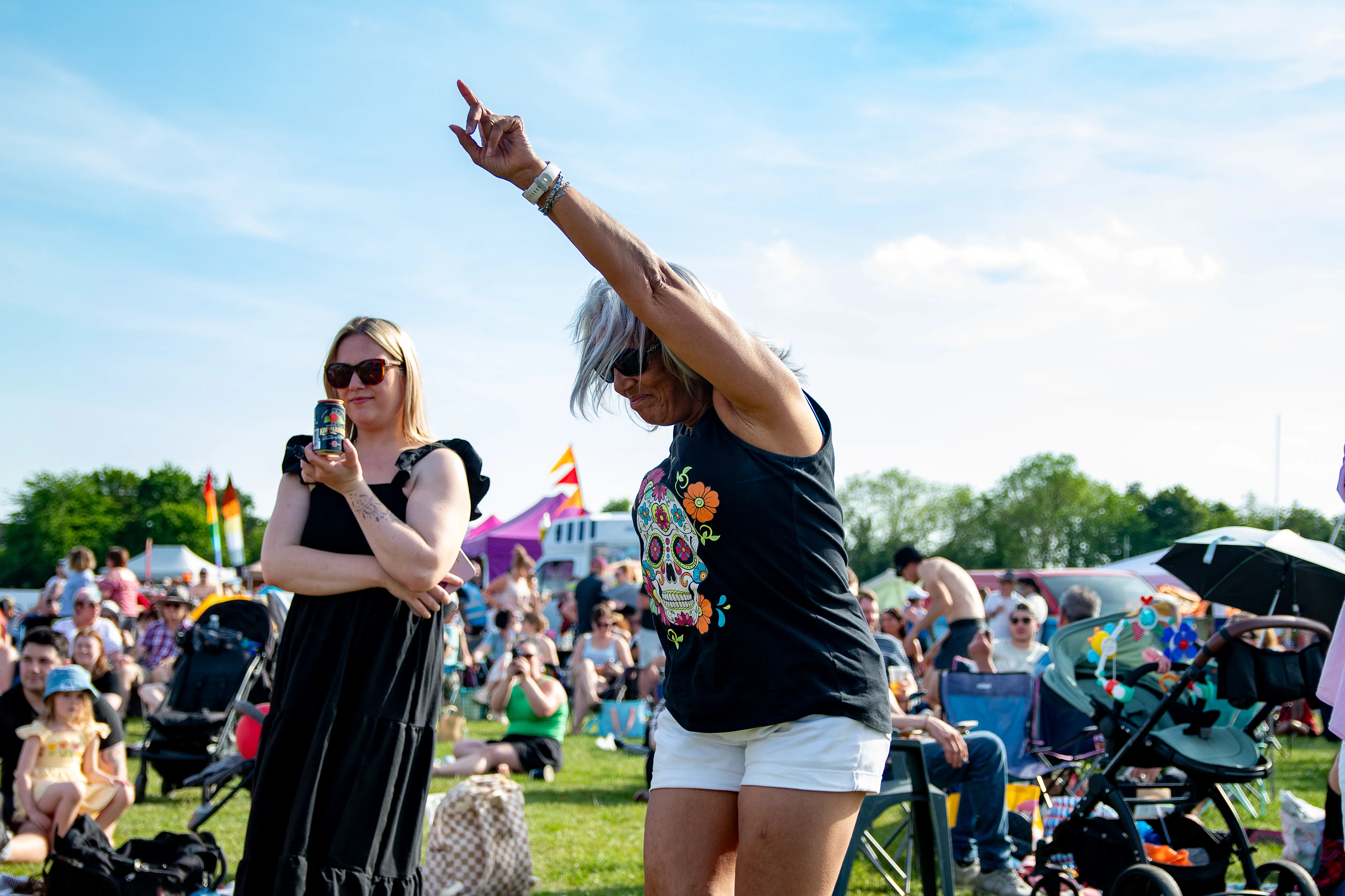 A woman pointing to the sky mid-dance in the crowd.