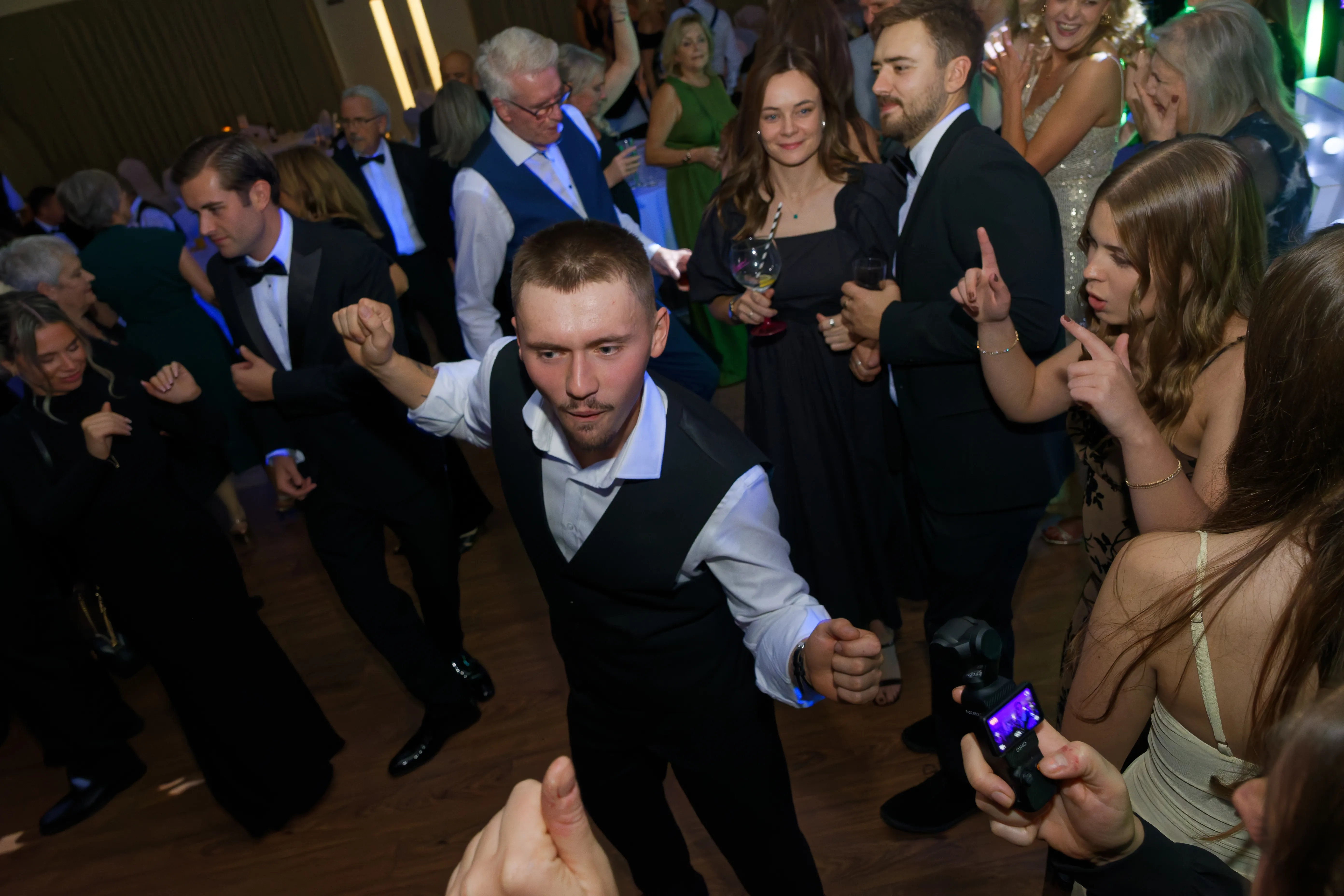 A young man in a waistcoat pulling shapes on the dancefloor.