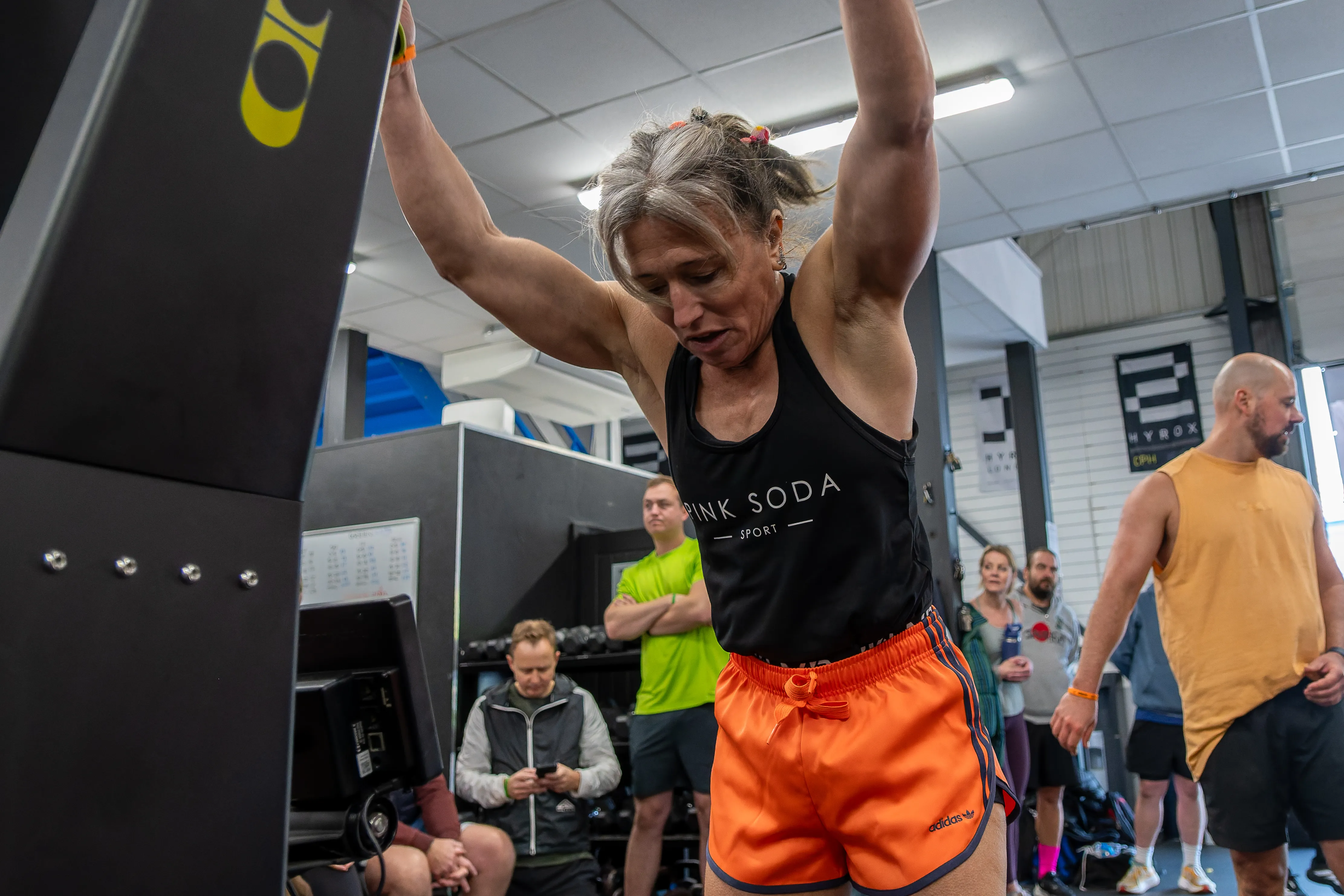 A competitor pulling hard on the ski erg, arms at full stretch.
