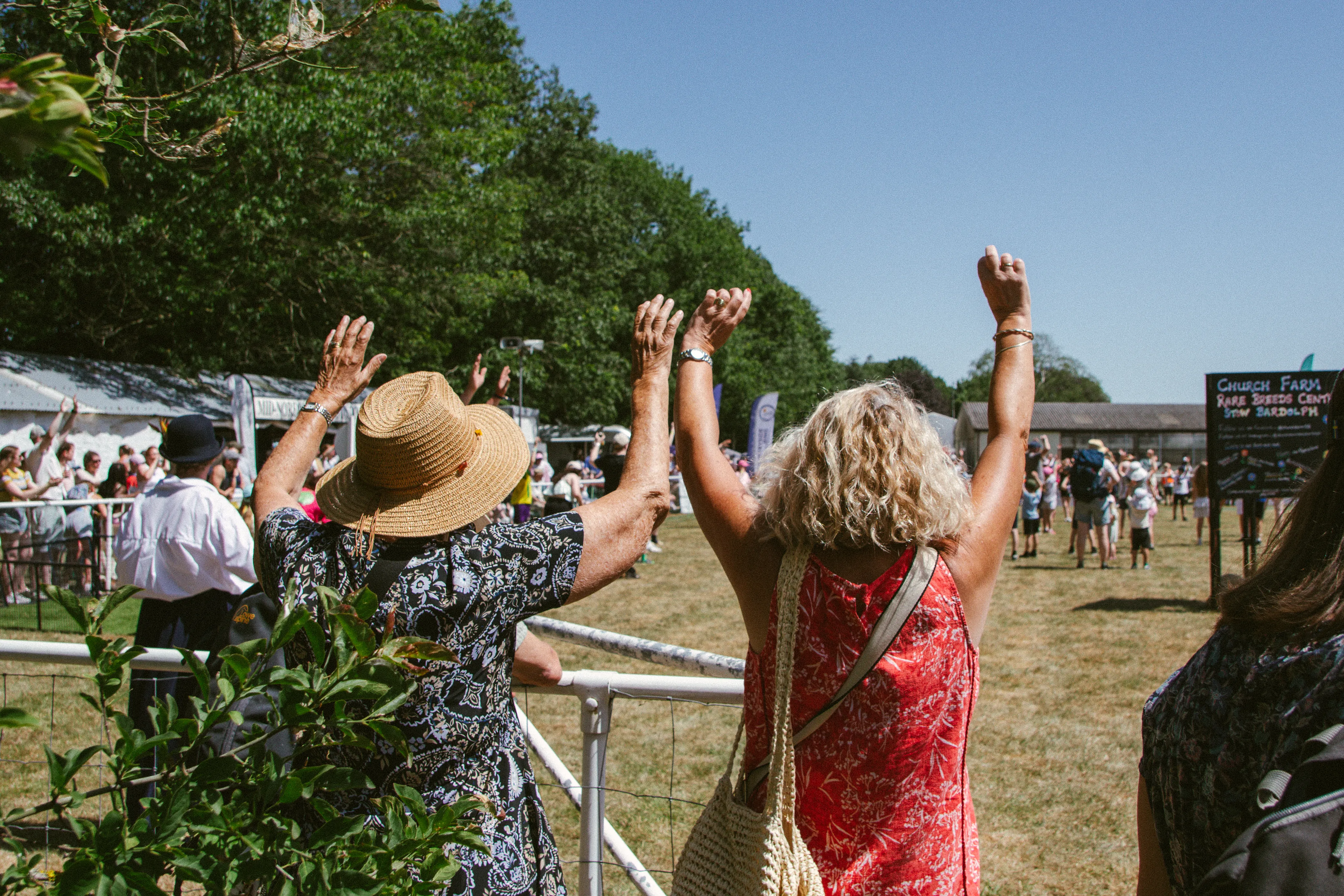 Spectators with arms raised, waving from the ringside.
