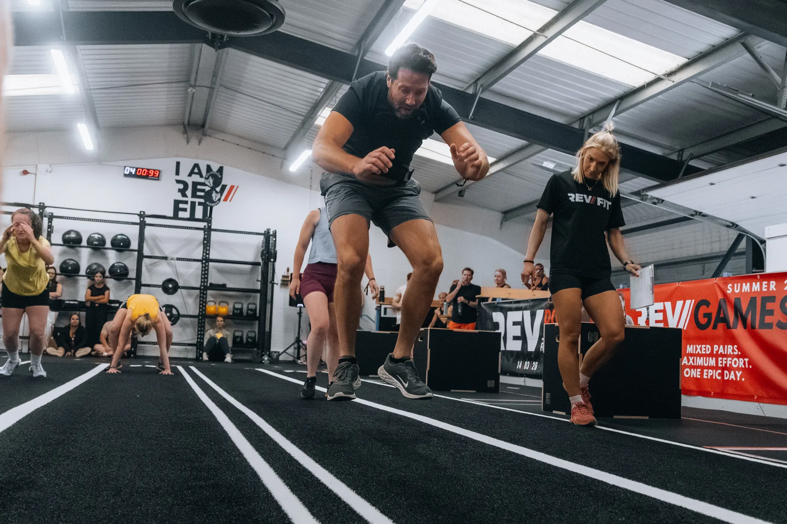 A competitor caught mid-air over the box during a fitness event.