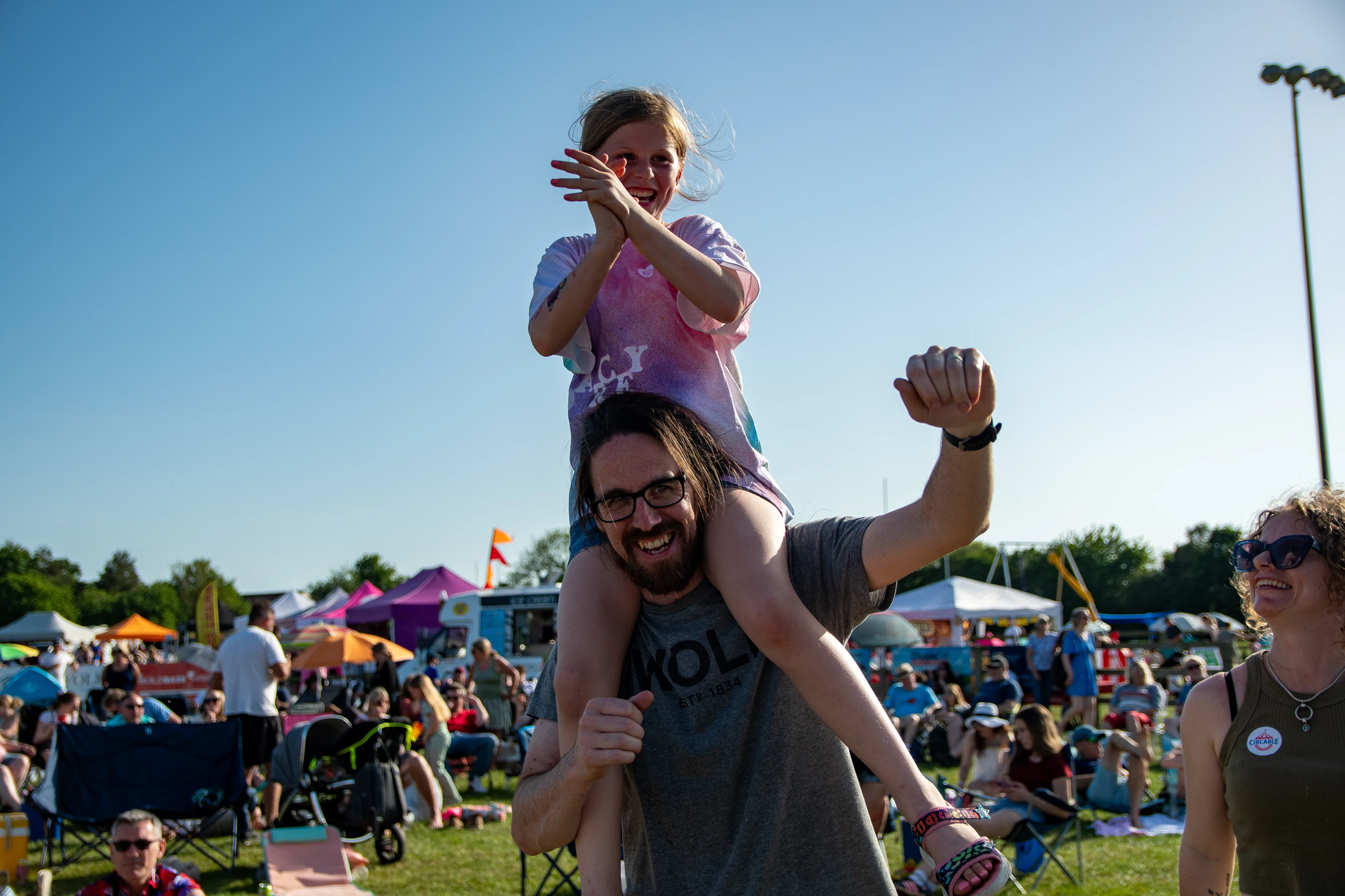 A child carried on shoulders through the festival crowd.