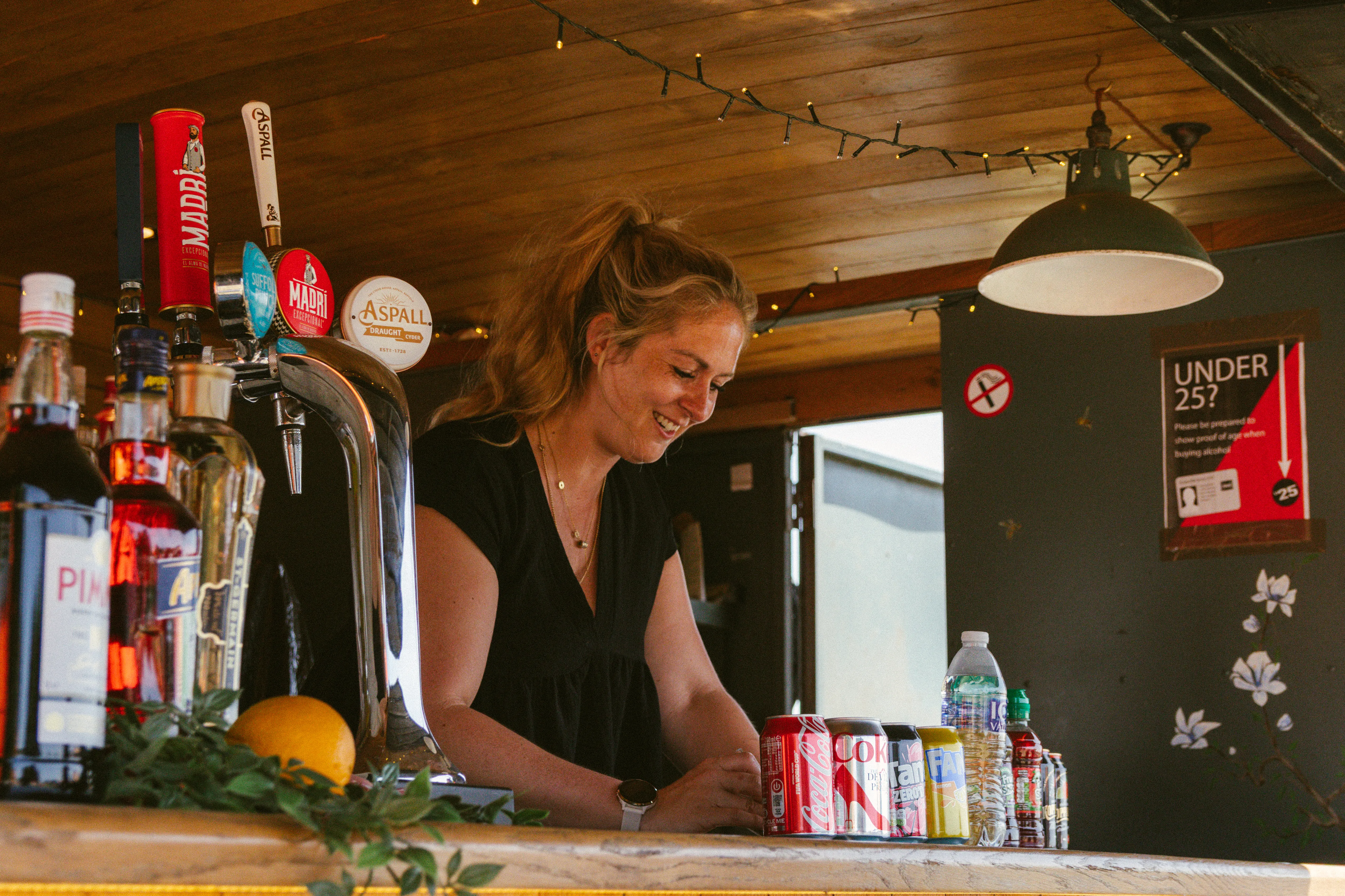 A bartender smiling as she serves at the showground bar.