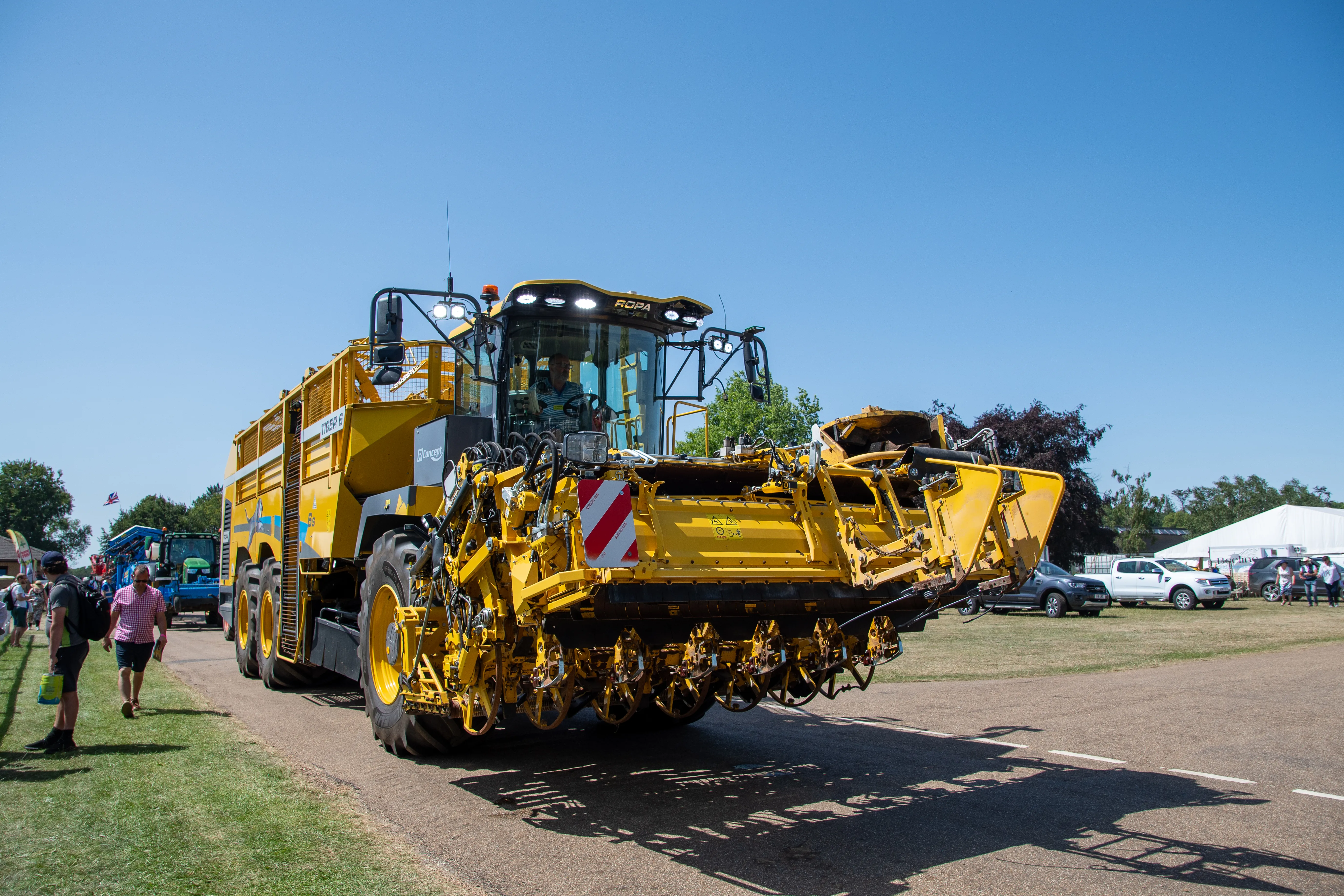 A yellow harvester on display drawing a crowd in the machinery lines.