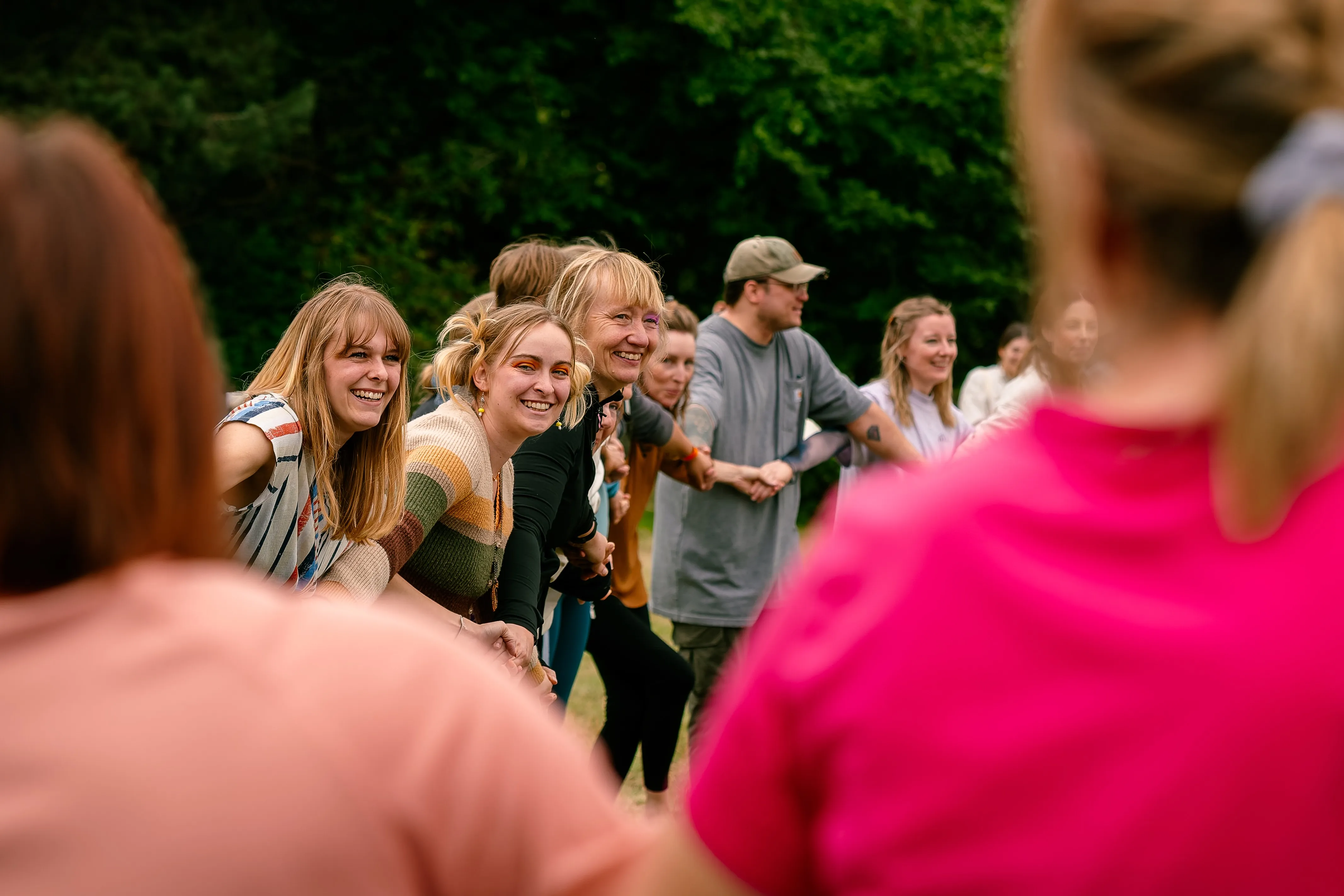 A group of women smiling together outdoors at a wellness festival.