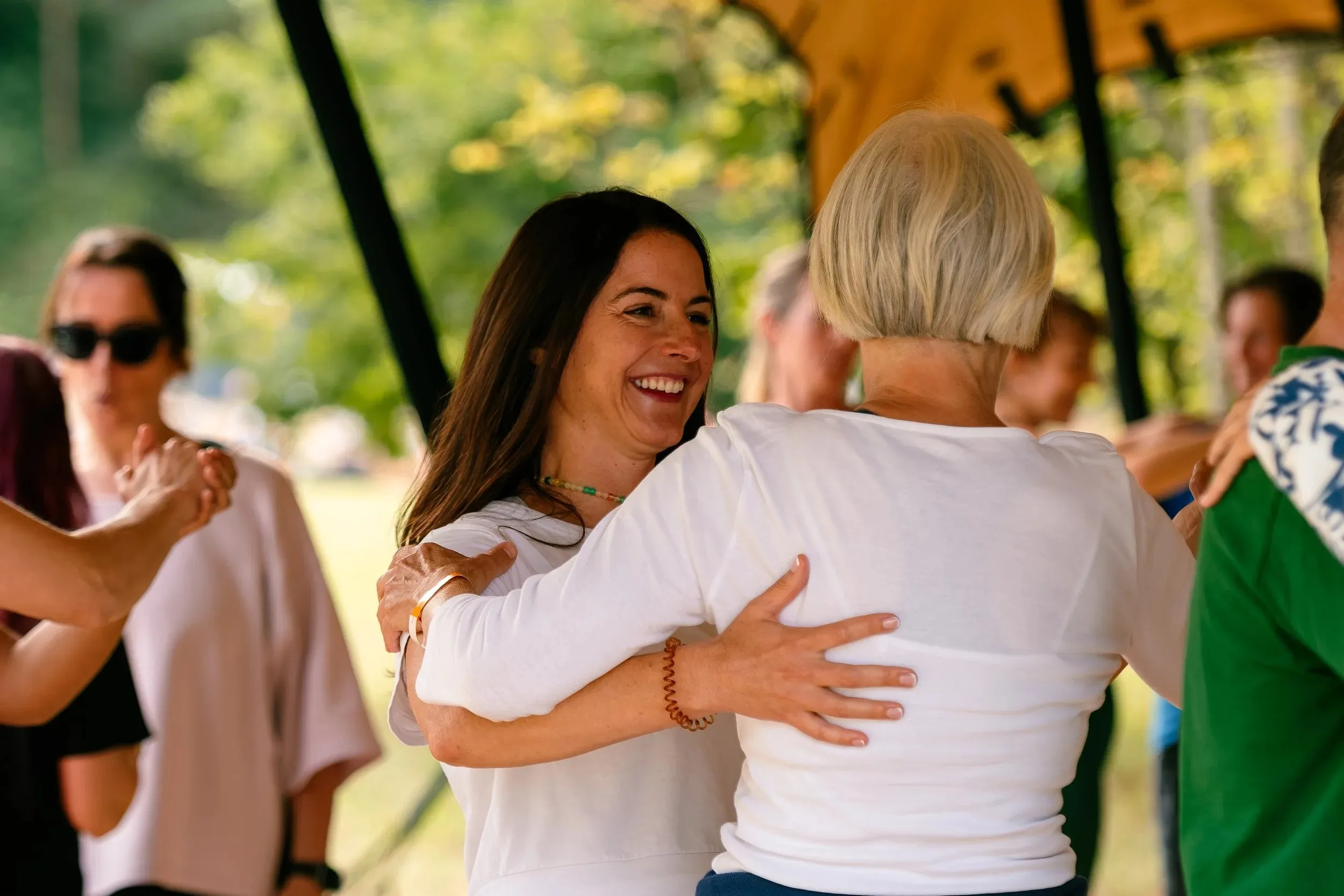 Two women sharing a warm hug in the middle of the crowd.