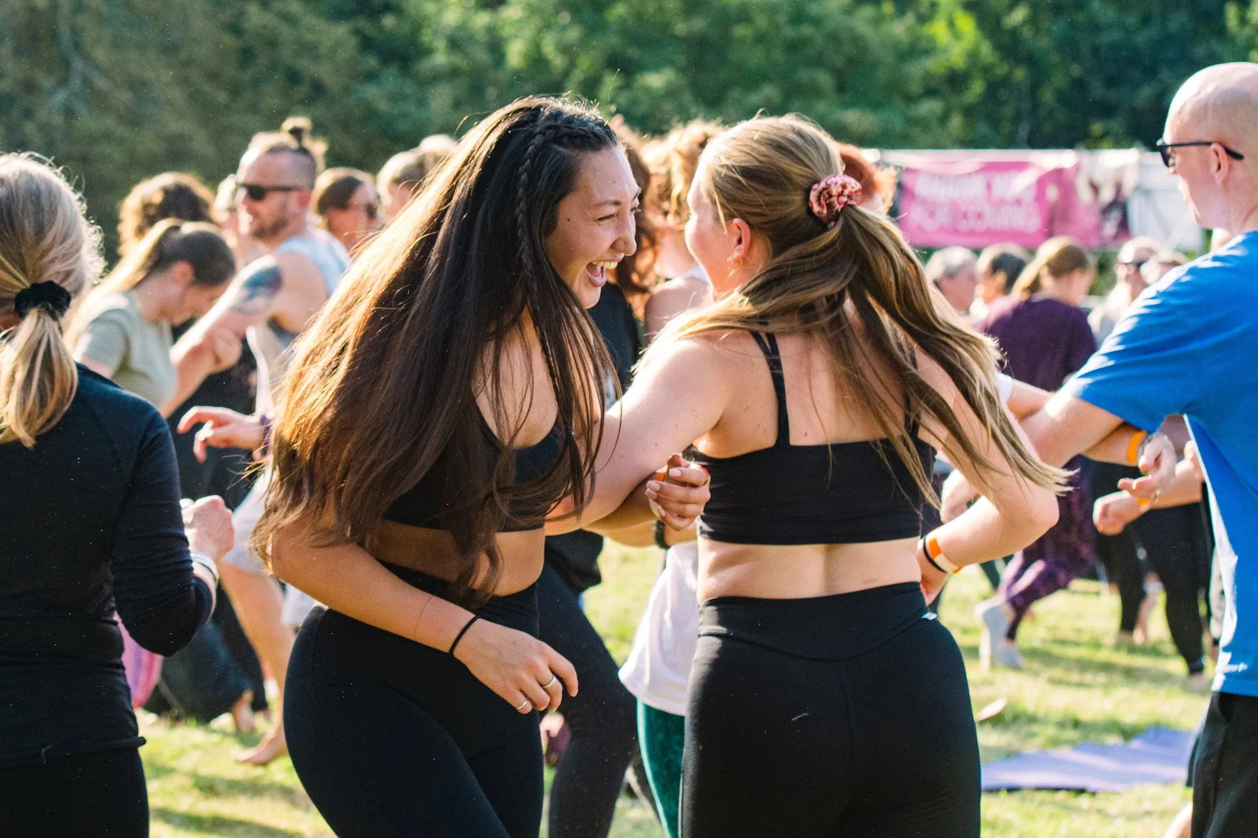 Two women with long dark hair dancing close together in the crowd.